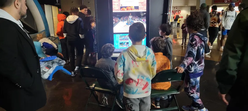 A Group of People Gathered to Look at a Screen